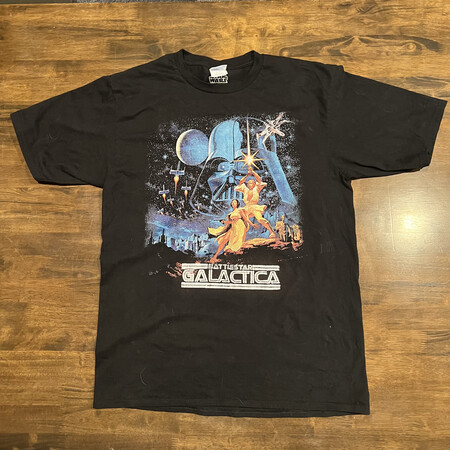 A black t-shirt with a Star Wars movie poster on it. Under it is the screen-printed text Battlestar Galactica.